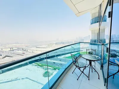 a balcony with a table and chairs on a building at Luxury 1BR The Bay Scenic Canal Creek Outlook in Dubai