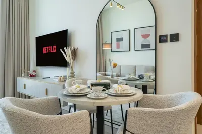 a living room with a table and chairs and a mirror at Comfortable 1-Bedroom Getaway Binghatti House in Dubai
