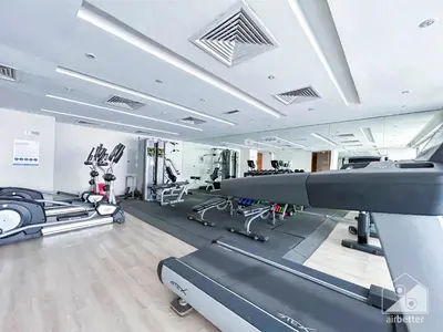 a gym with treadmills and elliptical machines at Stylish 1-Bedroom Retreat with Balcony Views in Dubai