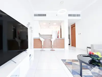 a living room with a large flat screen tv at Stylish 1-Bedroom Retreat with Balcony Views in Dubai