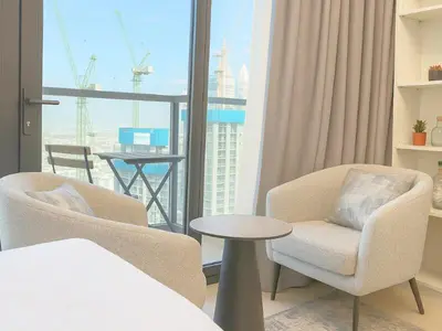 a room with two chairs and a table and a window at Dream Shoma -Cozy Studio In Business Bay in Dubai