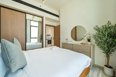 a bedroom with a large white bed and a mirror at Skyline Views from Binghatti House in Dubai
