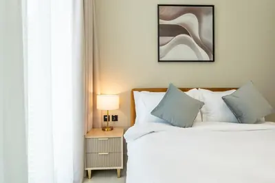a bedroom with two beds and a table with a lamp at Skyline Views from Binghatti House in Dubai