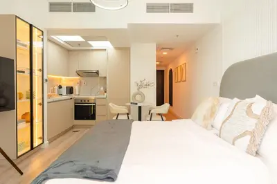 a bedroom with a large white bed and a kitchen at Keyrock - Dubai Marina Apartment with Stunning Sea View, Pool, Gym & Free Parking in Dubai