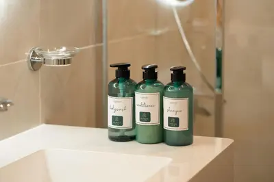 two green bottles sitting on top of a bathroom sink at Keyrock - Dubai Marina Apartment with Stunning Sea View, Pool, Gym & Free Parking in Dubai