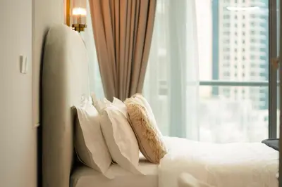 a hotel room with a couch with pillows and a window at Keyrock - Dubai Marina Apartment with Stunning Sea View, Pool, Gym & Free Parking in Dubai
