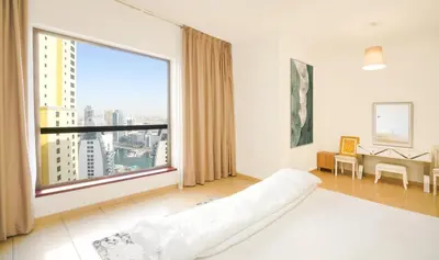 a large window in a room with a bed and a desk at Spacious 2 Bedroom in JBR with beach access in Dubai