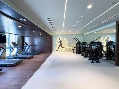 a gym with treadmills and exercise machines in it at Modern 1 BR in Creek Edge Ideal Family Living in Dubai