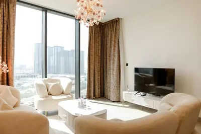 a living room with white furniture and large windows at SOBHA Hartland Grande 1 BHK in Dubai
