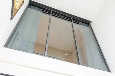 a window on the side of a house at Chic Duplex 1BHK by CzechIn Luxe Stay with Pool Gym in Dubai