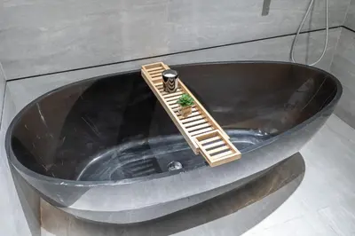 a black tub with a ladder and a plant in it at Chic Duplex 1BHK by CzechIn Luxe Stay with Pool Gym in Dubai