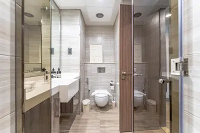 a bathroom with a toilet and two sinks and a toilet istg at MBL Lake VIEW 1 BR in Dubai