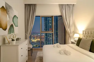 a white bedroom with a view of a city at MBL Lake VIEW 1 BR in Dubai