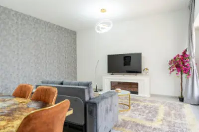 a living room with a couch and a tv at Nasma Luxury Stays - Jacuzzi Dreams 1 BR in Jumeirah in Dubai