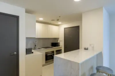 a kitchen with white cabinets and a counter top at Nasma Luxury Stays - Jacuzzi Dreams 1 BR in Jumeirah in Dubai