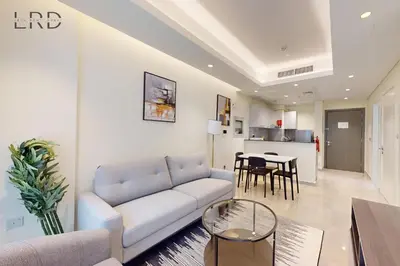 a living room with a couch and a table at Elegant and Modern 1BR Apartment in Dubai
