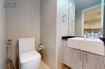 a bathroom with a white toilet and a sink at Elegant and Modern 1BR Apartment in Dubai