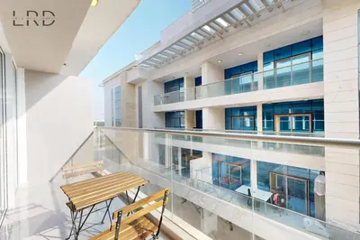 a balcony with a wooden bench and a building at Elegant and Modern 1BR Apartment in Dubai