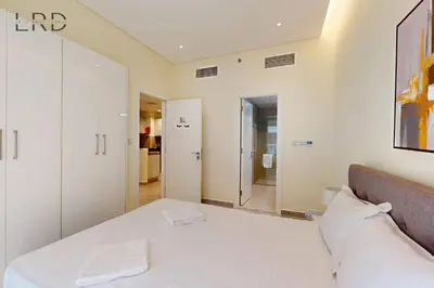 a bedroom with a white bed and a mirror at Elegant and Modern 1BR Apartment in Dubai