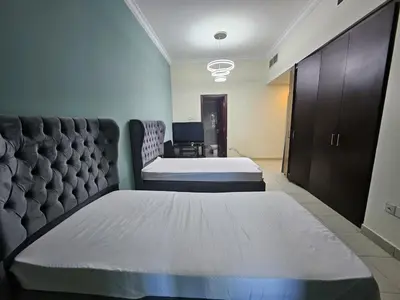 a hotel room with two beds and a couch at Budget Spacious Room Heart of marina in Dubai