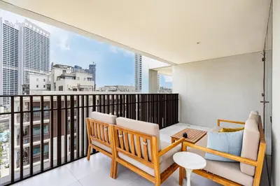 a balcony with a couch and chairs on a balcony at Lux Creek Home with Burj View steps from the Lagoon in Dubai