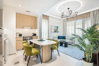 a kitchen and living room with a table and chairs at Lux Creek Home with Burj View steps from the Lagoon in Dubai