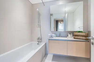 a bathroom with a tub and a sink and a mirror at Lux Creek Home with Burj View steps from the Lagoon in Dubai