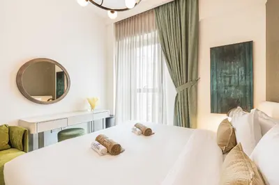 a bedroom with a white bed and a mirror at Lux Creek Home with Burj View steps from the Lagoon in Dubai