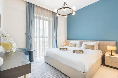 a bedroom with a large bed and a blue wall at Lux Creek Home with Burj View steps from the Lagoon in Dubai