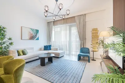 a living room with a couch and a table and chairs at Lux Creek Home with Burj View steps from the Lagoon in Dubai