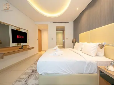 a hotel room with a large bed and a tv at Elegant 2 Bedroom Apartment with Pool Views at Business Bay 211DPA-2 in Dubai