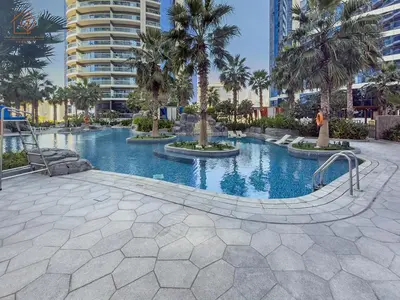 a swimming pool with palm trees in a resort at Elegant 2 Bedroom Apartment with Pool Views at Business Bay 211DPA-2 in Dubai