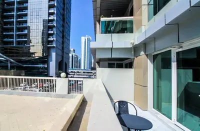 a black bench sitting on the side of a building at Spacious 1BR with Balcony in JLT Cluster E in Dubai