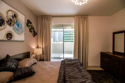 a bedroom with a large bed and a window at Spacious 1BR with Balcony in JLT Cluster E in Dubai
