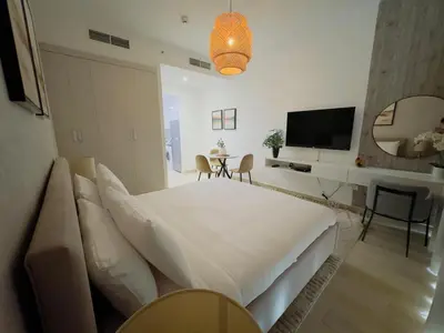 a bedroom with a bed and a table and a television at Sky-High Studio Marina Skyline View Bloom Tower in Dubai