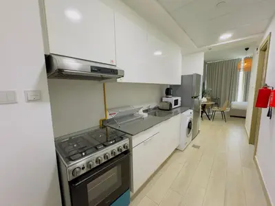 a kitchen with white cabinets and a stove top oven at Sky-High Studio Marina Skyline View Bloom Tower in Dubai