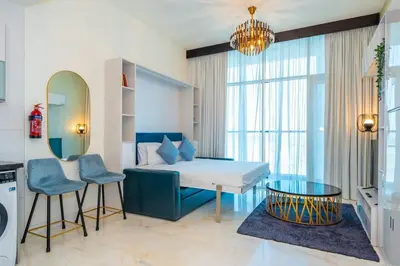 a room with a bed and a table and chairs at Stylish Studio Bayz Danube Burj Khalifa View Pool in Dubai