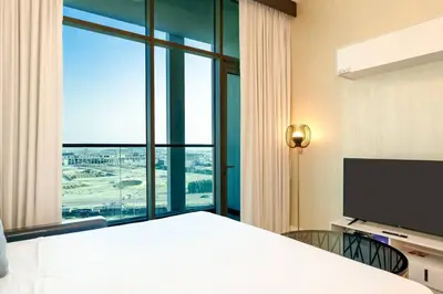 a hotel room with a bed and a large window at Stylish Studio Bayz Danube Burj Khalifa View Pool in Dubai