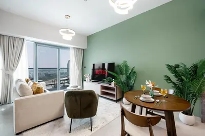 a living room with a table and a couch at Keyrock Golf Gate - Damac Hills Apartment with Pool, Gym & Free Parking in Dubai