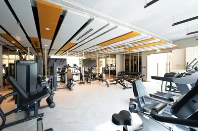a gym with treadmills and elliptical machines at Keyrock Golf Gate - Damac Hills Apartment with Pool, Gym & Free Parking in Dubai
