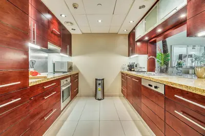 a large kitchen with wooden cabinets and counters at DAYF-BVE Large 1BR in Downtown Steps to Dubai Mall in Dubai