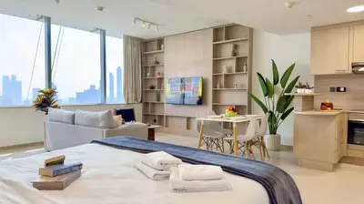 a bedroom with a bed and a table and a kitchen at DAYF-SKG High Floor Studio in Sky Gardens Heart of DIFC in Dubai