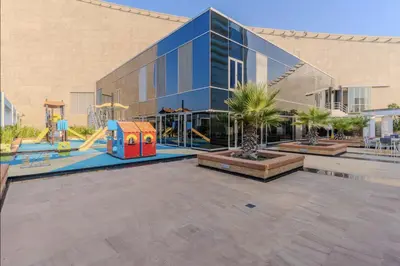 a large glass building with a playground in front of it at DAYF-SKG High Floor Studio in Sky Gardens Heart of DIFC in Dubai