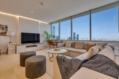 a living room with a couch and a tv at DAYF-SKG04 Modern Spacious 1 Bed Full DIFC Views in Dubai