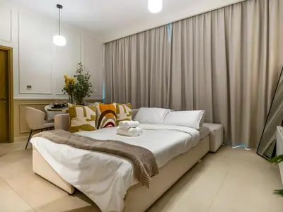 a bedroom with a large bed and a dining room at Chic 1BR in Downtown Dubai-Direct access to Dubai Mall in Dubai