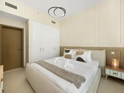 a bedroom with a large white bed in a room at Chic 1BR in Downtown Dubai-Direct access to Dubai Mall in Dubai