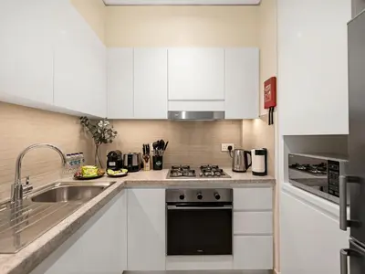 a kitchen with white cabinets and a sink at Chic 1BR in Downtown Dubai-Direct access to Dubai Mall in Dubai