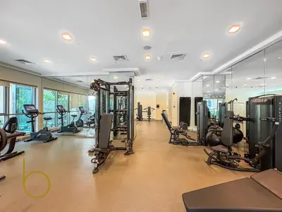 a gym with treadmills and machines in a room at Bookable - 2 Bedroom Boulevard Central in Dubai
