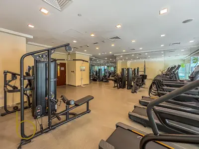 a gym with rows of treadmills and machines at Bookable - 2 Bedroom Boulevard Central in Dubai