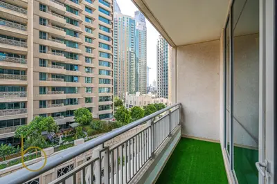 a balcony with a green floor and tall buildings at Bookable - 2 Bedroom Boulevard Central in Dubai